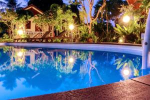 a swimming pool in front of a house at night at Phangan Lodge in Ban Tai