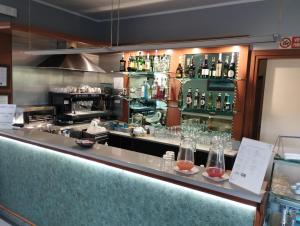 a bar with bottles and glasses on a counter at Hotel Motel Est in Peschiera Borromeo