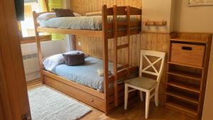 a room with two bunk beds and a chair at Moncayo Canfranc in Canfranc-Estación
