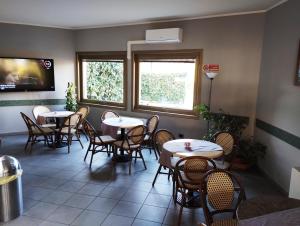 um restaurante com mesas e cadeiras num quarto em Hotel Motel Est em Peschiera Borromeo