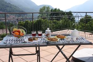una mesa con bandeja de desayuno en el balcón en B&B Le Magnolie, en Faggeto Lario 