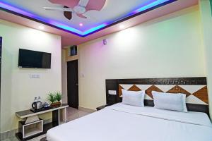 een slaapkamer met een bed en een televisie aan het plafond bij OYO HOTEL FLOWRA in Jangipur