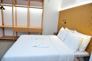 a bedroom with a large white bed with white pillows at Aikaterini Lever Du Soleil in Koskinou