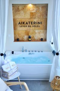 a bath tub in a bathroom with a sign on the wall at Aikaterini Lever Du Soleil in Koskinou