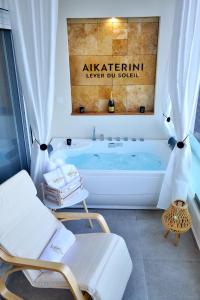 a bathroom with a tub and two chairs in front of it at Aikaterini Lever Du Soleil in Koskinou