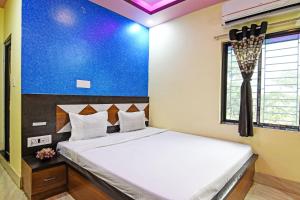 een slaapkamer met een groot bed met een blauwe muur bij OYO HOTEL FLOWRA in Jangipur