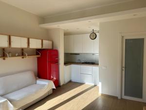 a kitchen with a red refrigerator and a couch at Appartamento Katy in Viareggio