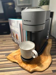 una cafetera sentada en una mesa de madera con una taza en The Beaver House en Belfast