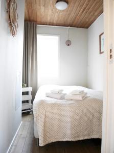 a bedroom with a bed with two towels on it at Cozy Hilltop Cottage With Fantastic View in Undenäs