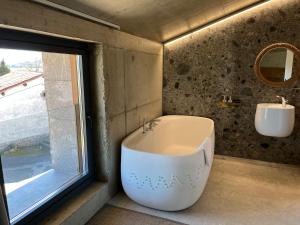 a bathroom with a tub and a sink and a window at Apartamento EKIALDE 