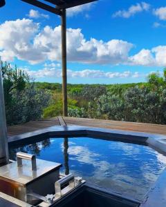 a swimming pool with a view of a field at Farm Stay: Enjoy Fynbos Views & Wood Fired Hot Tub in Hopefield