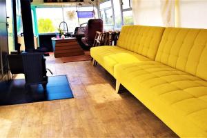 a yellow couch sitting in a room with ainylinylinylinylinylinylinyl at Farm Stay: Enjoy Fynbos Views & Wood Fired Hot Tub in Hopefield