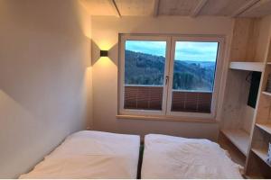 a bedroom with a bed in front of a window at Tinyhouse Wald(t)raum in Wilhelmsthal