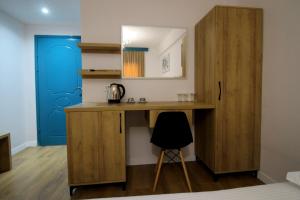 a desk in a room with a blue door at Ortus Rooms in Sarandë
