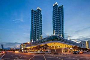 een gebouw met twee hoge gebouwen op een parkeerplaats bij Fantastic Seaview Loft 2R2B 9Pax #Maritime in Jelutong