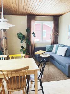 een woonkamer met een blauwe bank en een tafel bij Cozy Hilltop Cottage With Fantastic View in Undenäs
