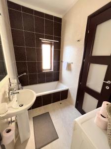 a bathroom with a sink and a tub and a toilet at Modern Spacious 2BD Penthouse with 2 Terraces - Close to Luqa Airport in Luqa