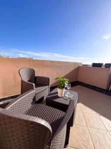 um pátio com 2 cadeiras e uma mesa na varanda em Modern Spacious 2BD Penthouse with 2 Terraces - Close to Luqa Airport em Luqa