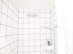 a bathroom with a shower with white tiled walls at Cozy Hilltop Cottage With Fantastic View in Undenäs