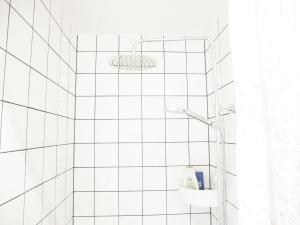 a bathroom with a shower with white tiled walls at Cozy Hilltop Cottage With Fantastic View in Undenäs +38 photos