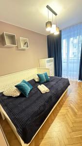 ein Schlafzimmer mit einem großen Bett mit blauen Kissen in der Unterkunft My Beloved Warsaw Żurawia Street in Warschau