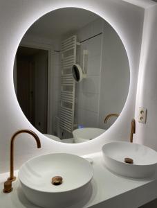 a bathroom with a white sink and a mirror at Morgenzon luxueus appartement in Knokke-Heist