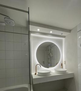 a bathroom with two sinks and a mirror at Morgenzon luxueus appartement in Knokke-Heist