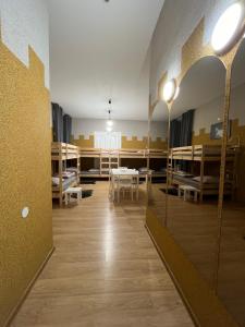 a room with beds and tables and a room with mirrors at Girls Hostel in Kraków
