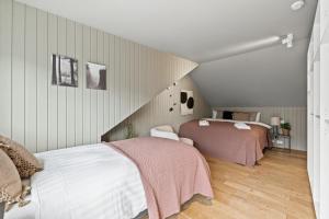 un dormitorio en el ático con 2 camas en una habitación en Venture Vacations-Massive Villa in Downtown Reykjavík with a Sauna en Reikiavik