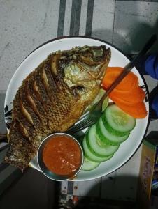 um prato de comida com peixe, pepinos e molho em Hotel crunchy em Deorāli