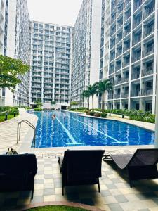 a large swimming pool in front of tall buildings at Scandi-Style & Organic condo Shore 3 MOA in Manila