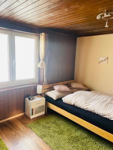 um quarto com uma cama e uma janela em Charmante Ferienwohnung direkt im Ski- und Wandergebiet em Schwarzenberg im Bregenzerwald