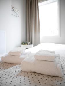 a white bedroom with white towels on a bed at Cozy Hilltop Cottage With Fantastic View in Undenäs