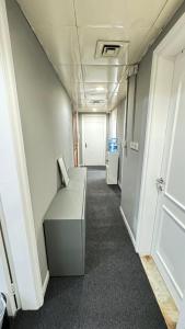 a hallway of an office with a desk and a door at Golden Horse Hostel in Dubai