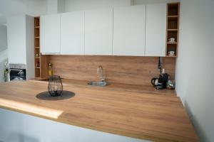 a kitchen with a wooden counter top with a sink at Apartment Una Laguna in Bihać