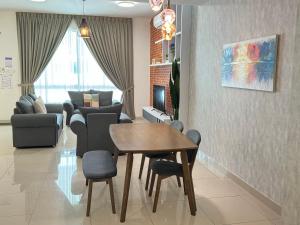 a living room with a wooden table and chairs at De Home Desaru Harmonia 5GWiFi Netflix BBQ 41OK7 in Bandar Penawar