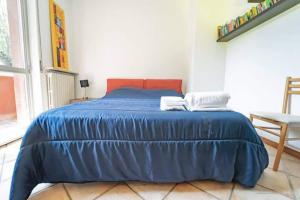 Una cama azul con 2 almohadas en un dormitorio en Trilocale comodo ai servizi, en Alessandria