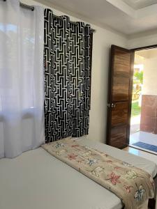a bedroom with a bed with a black and white headboard at Jancas Vacation Home Camiguin Family Room in Catarman