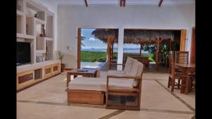 a living room with a couch and a tv and a table at Villa Agay in Nosy Be