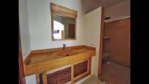 a bathroom with a wooden sink and a mirror at Villa Agay in Nosy Be