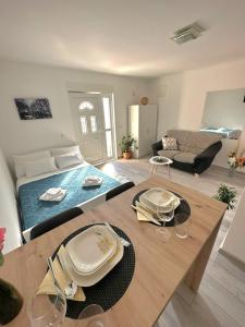 een woonkamer met een bed en een tafel met wijnglazen bij Studio apartman Antonio in Metković