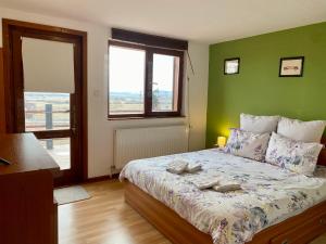 a bedroom with a bed with a green wall at Casa Genesini in Miercurea-Ciuc