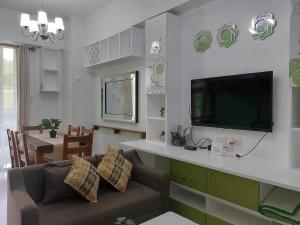 sala de estar con sofá y TV de pantalla plana en Pico De Loro staycation en Nasugbu