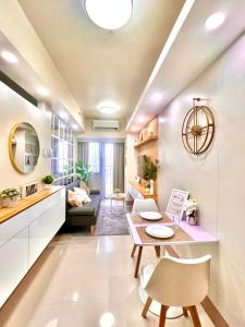 Il comprend une cuisine et un salon avec une table et un canapé. dans l'établissement Scandi-Style & Organic condo Shore 3 MOA, à Manille