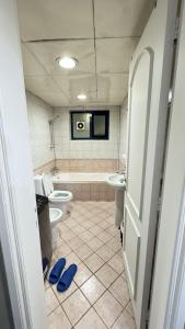 ein Badezimmer mit 2 WCs, einer Badewanne und einem Waschbecken in der Unterkunft Golden Horse Hostel in Dubai