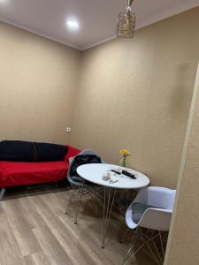 Habitación con mesa y cama con sofá rojo. en Apartment on L.Meskhishvili Turn, en Tiflis