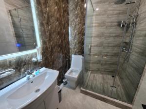 a bathroom with a shower and a toilet and a sink at Homy House Hotel in Tashkent