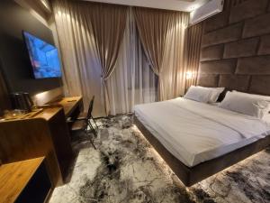 Dormitorio con cama, escritorio y TV en Homy House Hotel en Tashkent