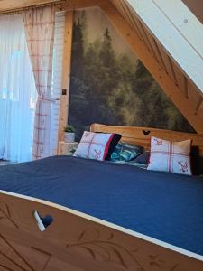 Bett in einem Zimmer mit Wandgemälde in der Unterkunft Apartamenty U Paliderki in Poronin