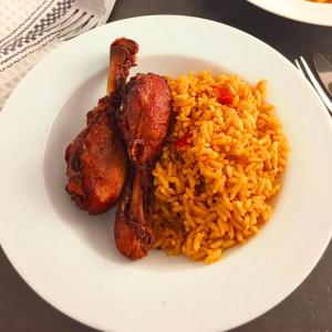 ein weißer Teller mit Reis und Fleisch in der Unterkunft Trending Place Hotel and Suites in Lagos